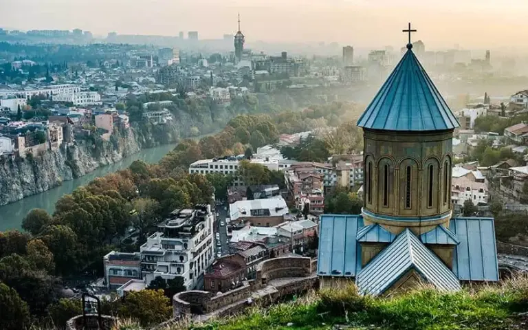 Een kerk boven de daken van Tbilisi
