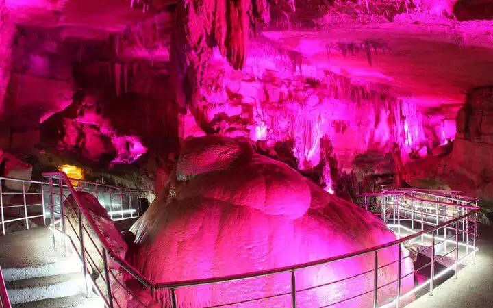 Gekleurd licht op de druipsteen van de Prometheus-grot