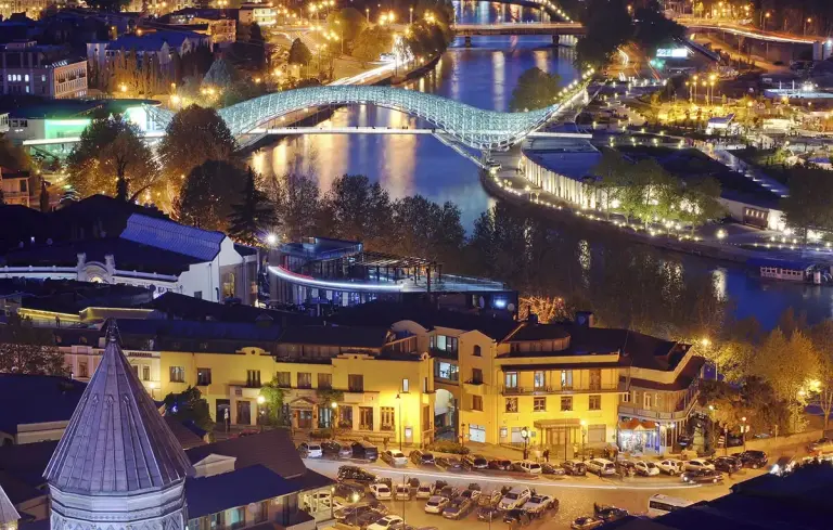 De Vredesbrug over de Mtkvari in Tbilisi bij avond