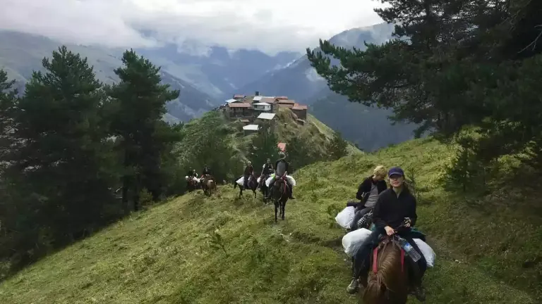 Wandelaars en paarden op een bergpad in Toesjeti