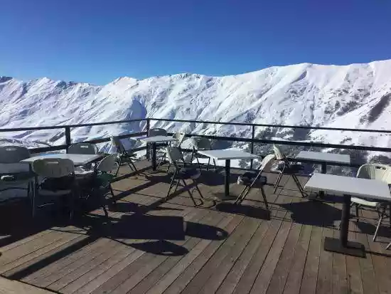 Een terras tegenover een besneeuwde bergkam