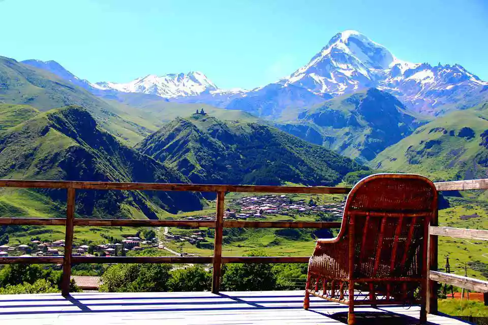 Stoel op een terras met uitzicht op de Kazbek boven Kazbegi