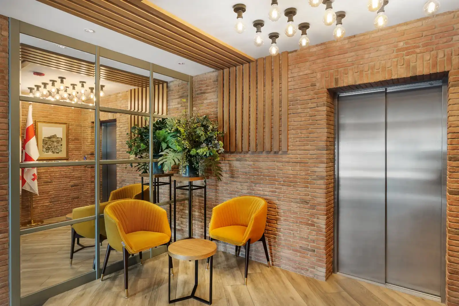 Lobby van een boutiquehotel in Tbilisi met bakstenen muren, houten lamellen en fluwelen fauteuils