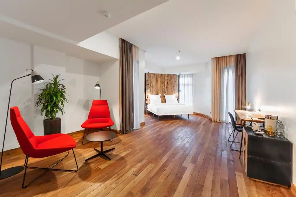 Ruime kamer met zithoek en houten vloer in een boutiquehotel in Tbilisi