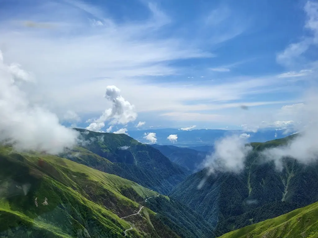Wolken drijven laag over de groene bergkammen van Toesjeti