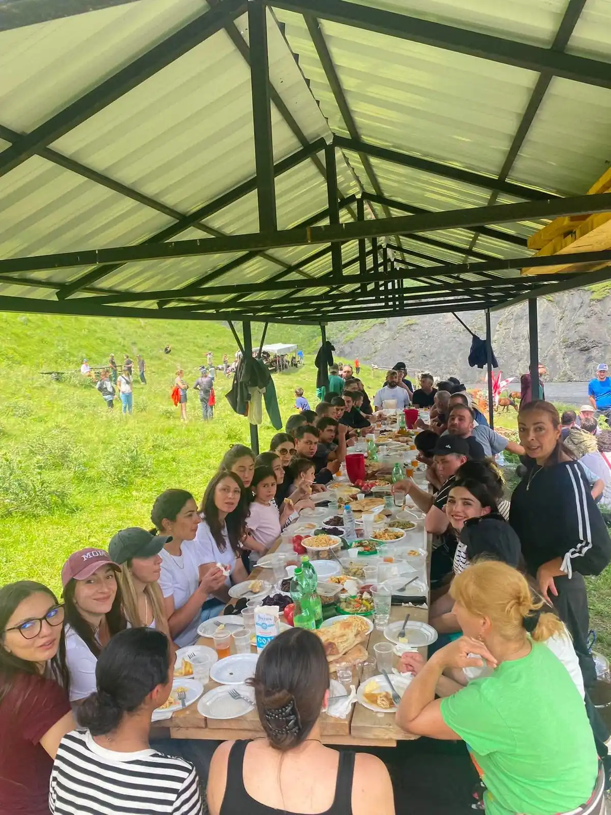 Lange tafel in de bergen, vol met Georgische gerechten en gedekt voor de hele groep